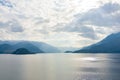 Beautiful aerial view of the famous Como Lake on sunny summer day. Clouds reflecting in calm waters of the lake with Alp mountains Royalty Free Stock Photo