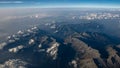 Beautiful aerial view on the Italian Alps on a sunny day with clear sky and low altitude clouds. Flying above mountains with some