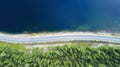 Beautiful aerial view of road between green summer forest and blue lake in Finland,Europe. Royalty Free Stock Photo