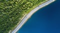 Beautiful aerial view of road between green summer forest and blue lake in Lapland. Car moving on road. Royalty Free Stock Photo