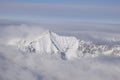 Beautiful aerial view of snow capped mountain peaks above clouds Royalty Free Stock Photo