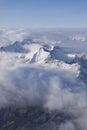 Beautiful aerial view of snow capped mountain peaks above clouds Royalty Free Stock Photo