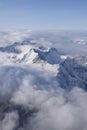 Beautiful aerial view of snow capped mountain peaks above clouds Royalty Free Stock Photo