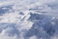 Beautiful aerial view of snow capped mountain peaks above clouds Royalty Free Stock Photo