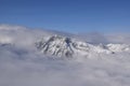 Beautiful aerial view of snow capped mountain peaks above clouds Royalty Free Stock Photo