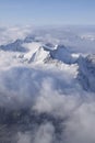 Beautiful aerial view of snow capped mountain peaks above clouds Royalty Free Stock Photo