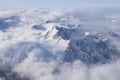 Beautiful aerial view of snow capped mountain peaks above clouds Royalty Free Stock Photo