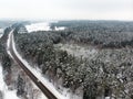 Beautiful aerial view of snow covered pine forests and a road winding among trees. Rime ice and hoar frost covering trees. Scenic Royalty Free Stock Photo