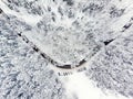 Beautiful aerial view of snow covered pine forests and a road winding among trees. Rime ice and hoar frost covering trees. Scenic Royalty Free Stock Photo