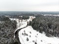 Beautiful aerial view of snow covered pine forests and a road winding among trees. Rime ice and hoar frost covering trees. Scenic Royalty Free Stock Photo