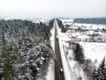 Beautiful aerial view of snow covered pine forests and a road winding among trees. Rime ice and hoar frost covering trees. Scenic Royalty Free Stock Photo