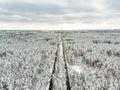 Beautiful aerial view of snow covered pine forests and a road winding among trees. Rime ice and hoar frost covering trees. Winter Royalty Free Stock Photo