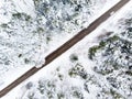 Beautiful aerial view of snow covered pine forests and a road winding among trees. Scenic winter landscape near Vilnius, Lithuania Royalty Free Stock Photo