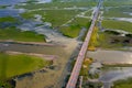 Beautiful aerial view of traffic on elevated road and tollway surrounded green rice fields Royalty Free Stock Photo