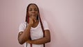 Beautiful african american adult woman rocks braids, pondering with doubt, a pipe dream over her mind, standing over an isolated Royalty Free Stock Photo