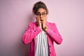 Beautiful african american businesswoman wearing jacket and glasses over pink background afraid and shocked, surprise and amazed Royalty Free Stock Photo