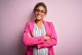 Beautiful african american businesswoman wearing jacket and glasses over pink background happy face smiling with crossed arms Royalty Free Stock Photo