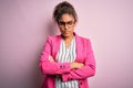 Beautiful african american businesswoman wearing jacket and glasses over pink background skeptic and nervous, disapproving Royalty Free Stock Photo