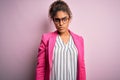 Beautiful african american businesswoman wearing jacket and glasses over pink background skeptic and nervous, frowning upset Royalty Free Stock Photo