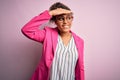 Beautiful african american businesswoman wearing jacket and glasses over pink background very happy and smiling looking far away Royalty Free Stock Photo