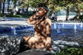 African american  female fashion model with an Afro is sitting in a park by in Chicago. Royalty Free Stock Photo