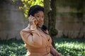 African american female fashion model with an Afro is sitting in a park by in Chicago. Royalty Free Stock Photo