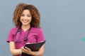 Beautiful african american female pediatric nurse holding pen and paper taking notes