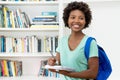 Beautiful african american female student with backpack writing notes Royalty Free Stock Photo