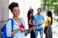 Beautiful african american female student with tablet computer and group of young adults Royalty Free Stock Photo