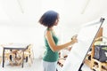 Beautiful African American girl with dark curly hair standing near board and giving presentation to colleagues in office Royalty Free Stock Photo