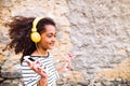 Beautiful african american girl with headphones, listening music Royalty Free Stock Photo