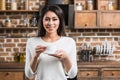 beautiful african american girl holding cup of coffee and smiling at camera Royalty Free Stock Photo