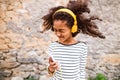 Beautiful african american girl with smart phone and earphones. Royalty Free Stock Photo