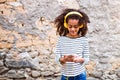 Beautiful african american girl with smart phone and earphones. Royalty Free Stock Photo