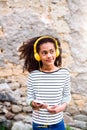 Beautiful african american girl with smart phone and earphones. Royalty Free Stock Photo