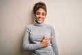 Beautiful african american girl wearing turtleneck sweater standing over white background cheerful with a smile of face pointing Royalty Free Stock Photo
