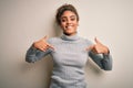 Beautiful african american girl wearing turtleneck sweater standing over white background looking confident with smile on face, Royalty Free Stock Photo