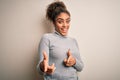 Beautiful african american girl wearing turtleneck sweater standing over white background pointing fingers to camera with happy Royalty Free Stock Photo