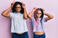 Beautiful african american mother and daughter wearing casual clothes and glasses doing funny gesture with finger over head as