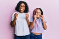 Beautiful african american mother and daughter wearing casual clothes and glasses excited for success with arms raised and eyes Royalty Free Stock Photo