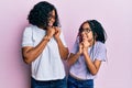 Beautiful african american mother and daughter wearing casual clothes and glasses laughing nervous and excited with hands on chin Royalty Free Stock Photo