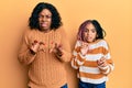 Beautiful african american mother and daughter wearing wool winter sweater disgusted expression, displeased and fearful doing Royalty Free Stock Photo