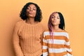 Beautiful african american mother and daughter wearing wool winter sweater looking at the camera blowing a kiss on air being Royalty Free Stock Photo