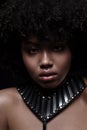 Beautiful african american nacked woman with curly hairstyle wearing leather necklace with metal inserts