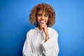 Beautiful african american sporty woman wearing casual sweatshirt over blue background looking confident at the camera with smile Royalty Free Stock Photo