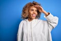 Beautiful african american sporty woman wearing casual sweatshirt over blue background very happy and smiling looking far away Royalty Free Stock Photo
