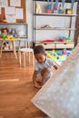 Beautiful african american toddler putting on shoes outside tipi at kindergarten