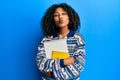 Beautiful african american woman with afro hair holding books looking at the camera blowing a kiss being lovely and sexy Royalty Free Stock Photo