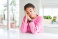 Beautiful african american woman with afro hair wearing casual pink sweater sleeping tired dreaming and posing with hands together Royalty Free Stock Photo
