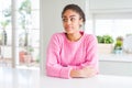 Beautiful african american woman with afro hair wearing casual pink sweater smiling looking to the side and staring away thinking Royalty Free Stock Photo